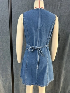 Detailansicht der Jeanskleid-Rückseite mit langem Metallreißverschluss und Taillenschleife