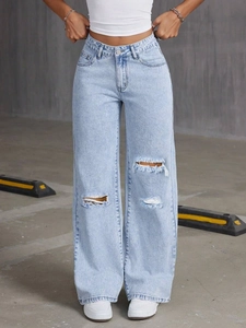 Detail of high-waisted distressed wide-leg jeans in light blue snow wash with ripped knees