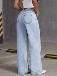 Detail view of high-waisted wide-leg jeans in light blue wash from a back perspective