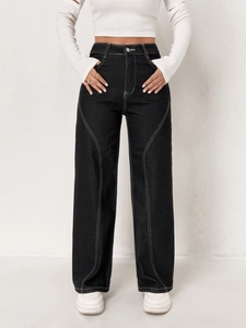 Detail of high-waisted black wide-leg jeans with contrast white stitching and metal button