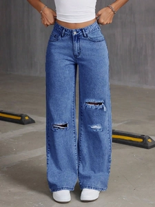 Close-up of distressed ripped knee details and vintage whiskers on high-waisted wide leg jeans