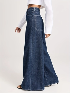 Détail de ce jean évasé à taille haute bleu foncé avec de grandes poches à l'arrière