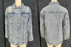 Detail of light blue washed denim jacket with distressed ripped holes and metal buttons