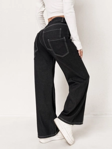 Detail view of black high-waisted wide-leg jeans with white contrast stitching and cargo pockets