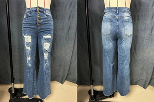 Detail of high waisted blue flared jeans featuring five buttons and distressed ripped details