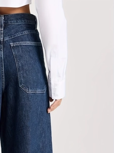 Détails de ce jean évasé taille haute bleu foncé avec coutures précises et texture denim