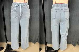 Detail of light blue straight denim jeans with elastic drawstring waist and contrast stitching