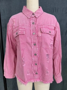 Close-up of pink washed denim shirt featuring distressed holes and metal buttons