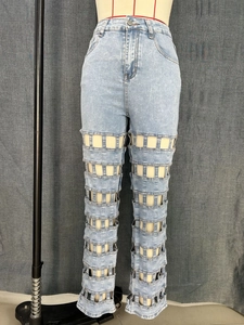 Detail of high-waisted light blue denim jeans with unique horizontal cutout mesh panels