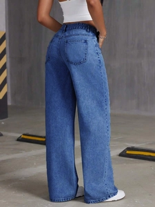 Rear view of high-waisted wide-leg jeans in light blue washed denim on model