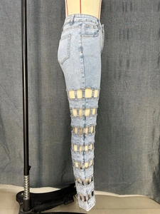 Macro detail of hollow rectangular grid cutout on light blue high waist denim jeans