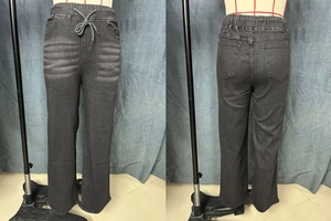Close-up of drawstring elastic waist and washed texture on gray wide leg jeans