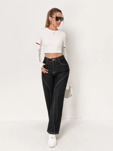 Full view of wide leg cargo jeans with white contrast stitching and cut-out sleeve top