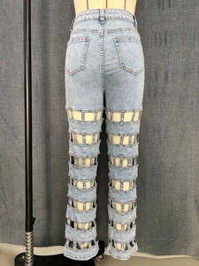 Detail of light blue high waisted wide leg jeans with ladder style cut-out patchwork design