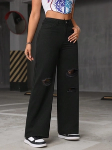 Detail of ripped knee and distressed fabric on these high-waisted black wide leg jeans
