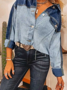 Detail of color-block cropped denim jacket with raw hem and silver metal buttons