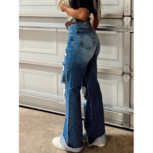 Women's high waist flare jeans with heavy distressed ripped sides and frayed hem detail