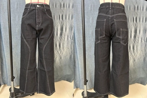 Detailed view of black wide-leg cargo jeans with contrast white stitching and curved paneling