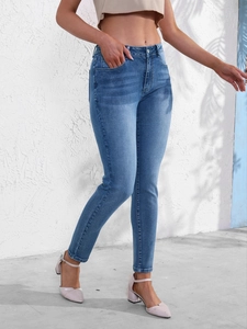 Gros plan sur un jean skinny bleu clair avec taille haute et texture denim délavé