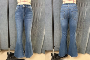 Detail of blue flare jeans showing double-button closure and washed whisker effect