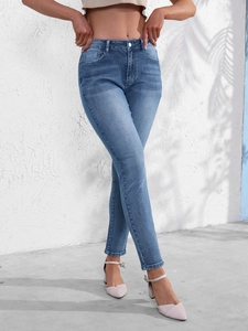 Gros plan sur un jean ajusté bleu avec taille mi-haute et détail de boutonnière