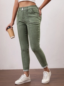 Détail d'un jean slim vert olive avec taille à double bouton et coutures avant élégantes