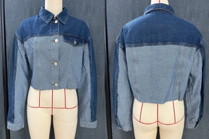 Detail of two-tone patchwork cropped denim jacket with frayed hem and long sleeves