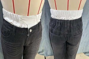 Detail of adjustable elastic waistband on low-rise black wide-leg straight jeans