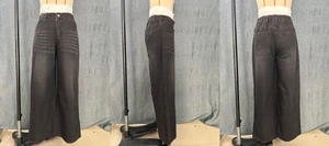 Macro detail of high waist elastic back and rear pockets on black wide leg denim jeans