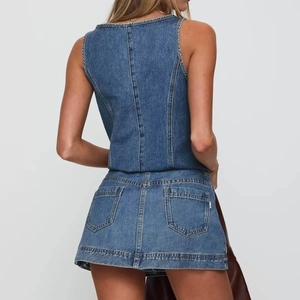 Détails des poches arrière et coutures de l'ensemble jupe courte en denim bleu