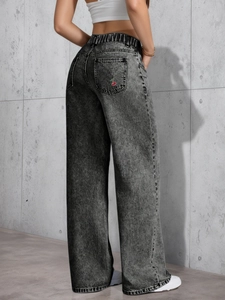 Close-up of cherry embroidery on the back pocket of grey high-waisted wide-leg jeans