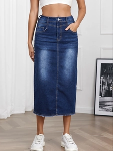 Close-up of high-waist denim skirt with metal buttons and distressed raw hem detail