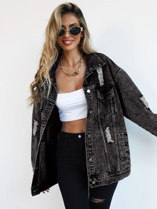 Close-up of oversized dark grey denim jacket with distressed ripped details and raw hem