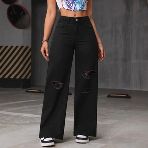 Women's black high-waisted distressed wide leg jeans with ripped knees in street style