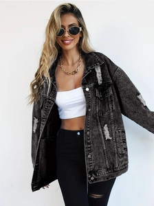 Close-up of washed black denim jacket featuring distressed ripped details and metal buttons