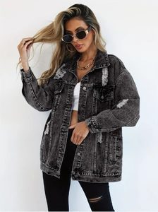 Close-up of a distressed grey denim jacket with heavy wash texture and frayed holes