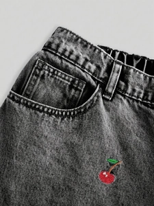 Macro shot of red cherry embroidery on high waist elastic denim pants for women