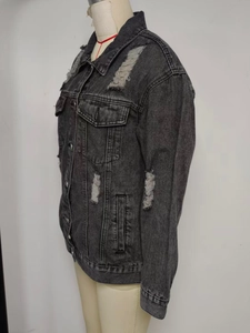 Detail view of distressed grey denim jacket with vintage wash and ripped punk style accents