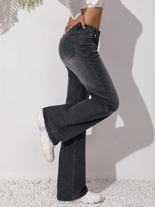 Dettaglio dei jeans a zampa a vita alta grigio scuro con lavaggio vintage e baffature