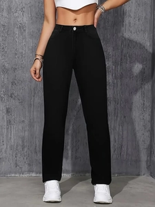 Détail du jean noir taille haute à jambe droite avec fermeture à un bouton classique