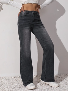 Dettaglio dei jeans neri a zampa con trama lavata e design moderno a vita alta sottile