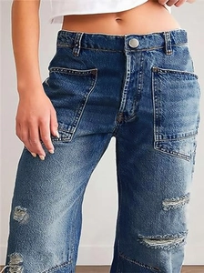 Detail view of high waist blue distressed jeans with large pockets and ripped denim