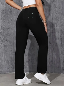 Gros plan d'un jean slim noir avec logo carré blanc sur la poche arrière du pantalon