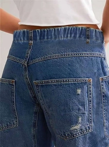 Close-up of distressed back pockets and elastic high waist on vintage baggy jeans