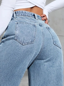 Detail of light blue high waisted denim jeans with classic back pockets and wash effect