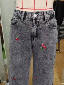 Close-up of cherry embroidery on wide-leg grey washed denim pants for women