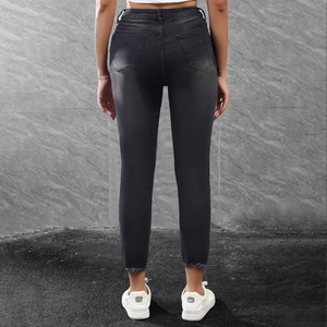 Close-up of the frayed hem detail on slim fit black cropped jeans for women