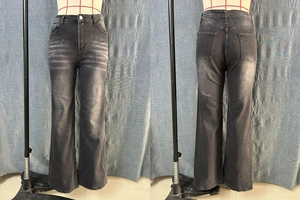 Dettaglio dei jeans svasati grigio scuro lavato rétro che mostrano fronte e retro su manichino