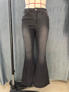 Detail of high waisted flared denim jeans in dark grey with polished metal button