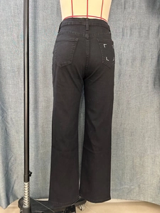Détail du jean noir à taille haute et jambe large avec broderie géométrique sur la poche